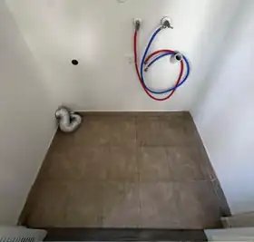 Example photo of washer hookups, dryer outlet and vent